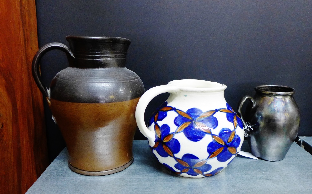 A selection of three jugs to include a stoneware two tone jug, an art pottery floral decorated jug