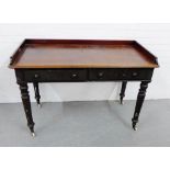 A mahogany side table with three quarter ledgeback and sides, over two drawers, raised on turned