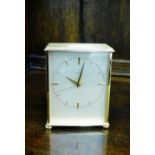 A Garrard brass cased clock, the silvered dial with brass hour batons, on bun feet, 14cm high
