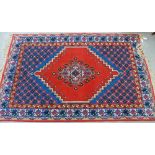 A Turkish rug, the red field with central foliate medallion with sapphire spandrels and multiple