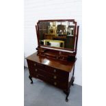A mahogany dressing table with mirror back and three ledge drawers over an arrangement of three long
