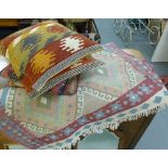 A collection of four Kilim covered and linen cushions, together with a flatweave contemporary
