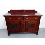 A mahogany ledgeback sideboard, the rectangular top over two frieze drawers and pair of carved
