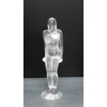 A Lalique glass female nude, modelled standing on a circular base with etched marks to base, 19cm