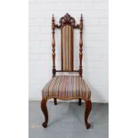 A mahogany framed hall chair with leaf carved toprail and striped upholstered back and seat, on