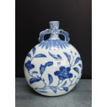 A Chinese blue and white moon flask with scroll handles to the neck with leaf and foliate pattern,
