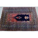 An Eastern style rug with blue panel to centre with basket of flower and hanging lantern pattern