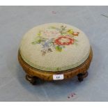 A walnut circular foot stool with tapestry top