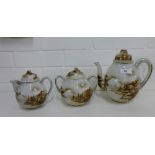 A Japanese porcelain teapot, twin handled sugar bowl and milk jug and covers painted with pagoda