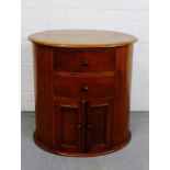 A contemporary hardwood oval chest with two short drawers and a pair of panel cupboard doors to