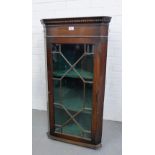 A 19th century mahogany corner cabinet, the dentil cornice above a glazed door with a shelved