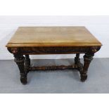 An oak carved table, the rectangular top over foliate and mask head carved frieze, raised on
