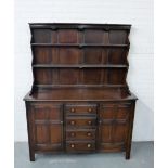 A dark oak Ercol style kitchen dresser with plate back over a rectangular base fitted four central