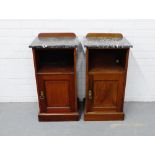 A pair of mahogany ledgeback bedside cabinets, each with a black marble top over open recess and