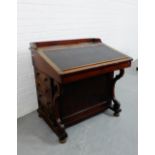 A mahogany Davenport, the slope front with inset skiver, with drawers and shaped supports to the