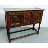 An oak cabinet, the rectangular top over a pair of carved arched pattern doors, on straight supports