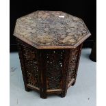 An Indian hardwood table, the octagonal top carved with fruit and vine