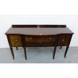 A mahogany ledgeback sideboard, the breakfront top over a central drawer flanked by cupboard