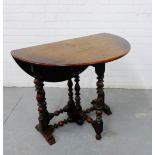 An oak drop leaf table, the circular top on turned supports, 70 x 84cm