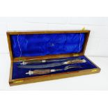 A three piece horn handled carving set in a mahogany fitted case by Walker & Hall