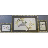 A collection of three silk embroidered panels depicting birds on foliate branches within faux bamboo