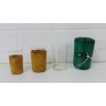 A collection of three glass beakers contained within a green leather case