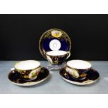A set of three Vienna porcelain cups and saucers with male and female figural panels against a