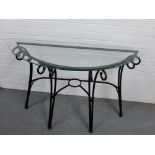 A contemporary demi lune table with glass top and black painted metal supports, 75 x 126cm