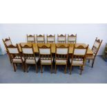 An oak extending dining table with three extra leaves and raised on turned baluster supports