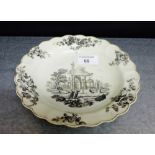 An 18th century Worcester plate with scalloped rim and with black painted scenes of a classical