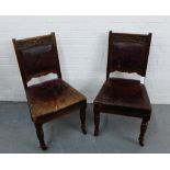 A pair of oak framed side chairs with brown leather upholstered backs and seats, on turned