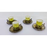 A set of four William Comyns London silver cup holders and saucers, with date letters ranging from