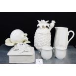 A quantity of white glazed ceramics to include a pineapple jar and cover, covered cups, jugs,