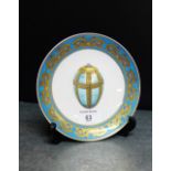 A Russian porcelain plate with heavily gilded pale blue border centred with an imperial Easter egg