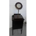 A mahogany shaving stand, the ledgeback top surmounted by a circular mirror, with a cupboard to