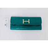 In the manner of Hermes a green leather purse, 19.5cm long