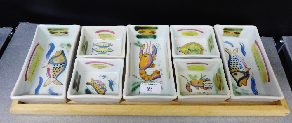 A vintage Buchan pottery hors d'oeurre set on wooden tray comprising seven rectangular and square