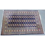 A Bokhara rug, the sapphire blue field with three rows of thirteen medallions within multiple