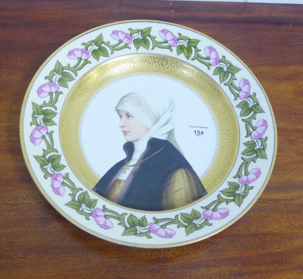 A continental porcelain charger painted with a female figure within a gilt and floral border, signed