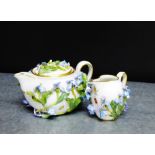 A Meissen floral encrusted miniature teapot and cream jug with blue cross swords marks, tallest 6cm