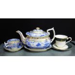 A 19th century blue and white Willow patterned teapot on stand with a matching cup and saucer,
