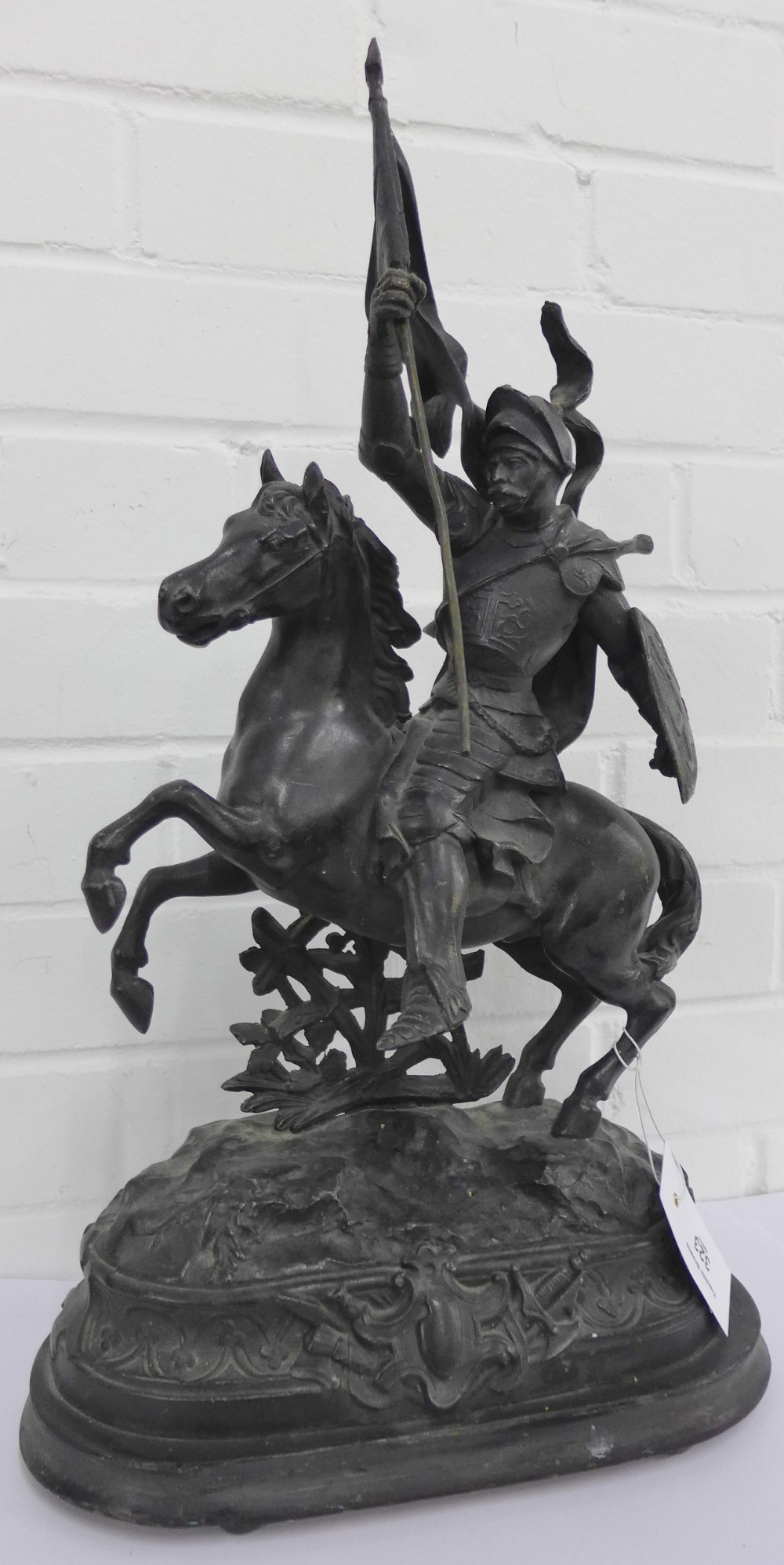 A Spelter figure of a flag bearing knight on horseback on an oval step base, 56cm high