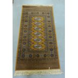 A bokhara style rug with a gold field, 190 x 92cm