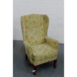 A floral upholstered wing armchair on cabriole supports, 102 x 70cm