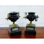 A pair of black hardstone and brass twin handled pedestal urns, 22cm high, (2)