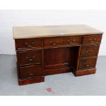 A mahogany desk, the rectangular top over an arrangement of seven drawers, 74 x 130cm