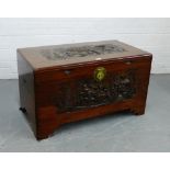 A carved camphor storage trunk, with ornate brass clasp to front, 57 x 101cm