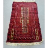 An Eastern prayer rug with a red field, 178 x 102cm