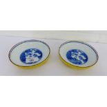 A pair of Japanese saucer dishes, the exterior with yellow glaze and the interior with blue and