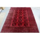 An Afghan rug, the red field with three rows of six octagons, 300 x 250cm